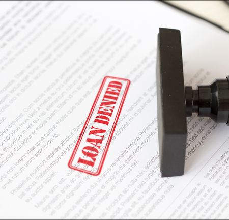 A piece of paper with a red Loan Denied stamp on it